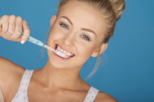 woman brushing her teeth because she believes in good oral hygiene