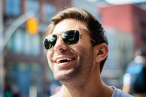 man in sunglasses smiling because he believes in gum disease prevention