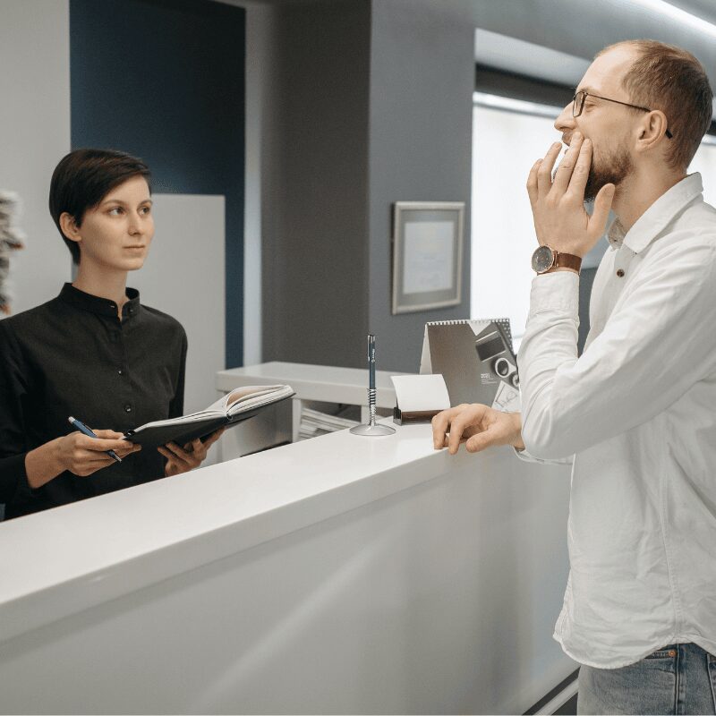 patient explaining dental issue to receptionist