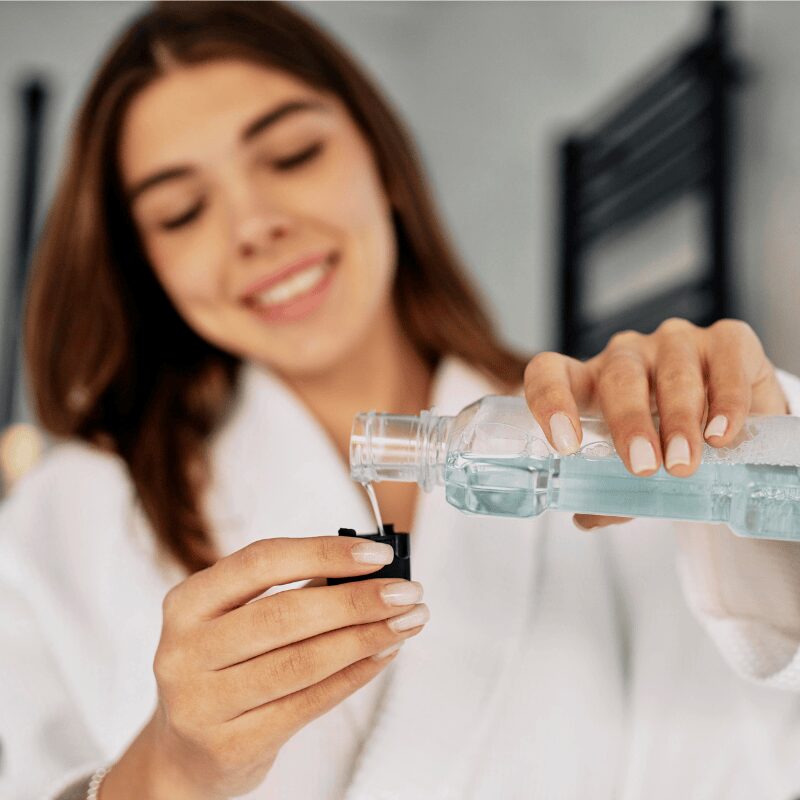 young woman pouring mouthwash